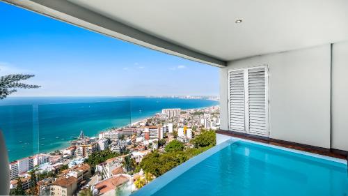 a room with a view of the ocean and a swimming pool at Avalon - 801 Top Sky Bar Pool 3 BR in Amapas in Puerto Vallarta
