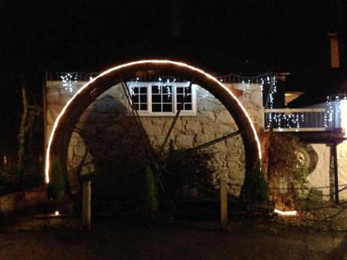 an arch with lights in front of a building at night at The Waterwheel in St Austell
