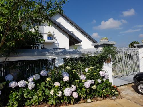 a garden of flowers in front of a fence at Tia Du Homestay in Da Lat