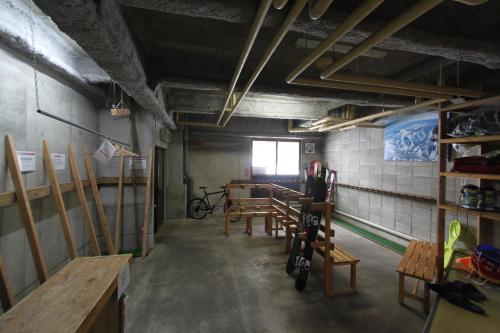 Habitación con mesas y sillas de madera. en Alpine Villa Nozawa, en Nozawa Onsen