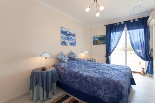 - une chambre avec un lit bleu et une fenêtre dans l'établissement Bella Vida Alfaz, à L'Alfàs del Pi