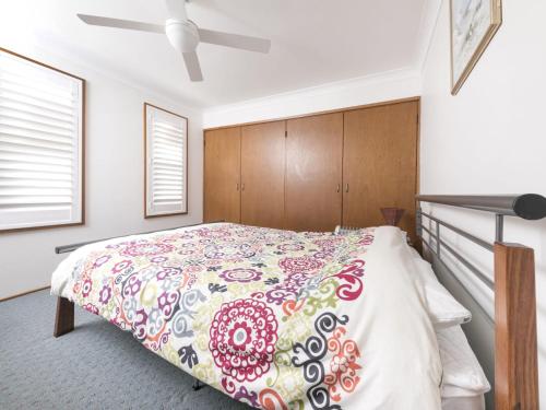 - une chambre dotée d'un lit avec un couvre-lit floral dans l'établissement Casa Pacifica Villa 4, à Forster