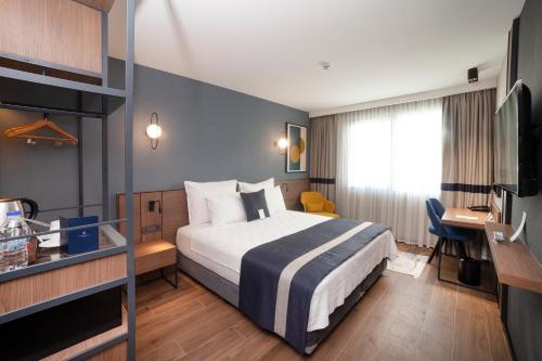 um quarto de hotel com uma cama e uma secretária em GRANBELLAHOTEL em Tekirdağ
