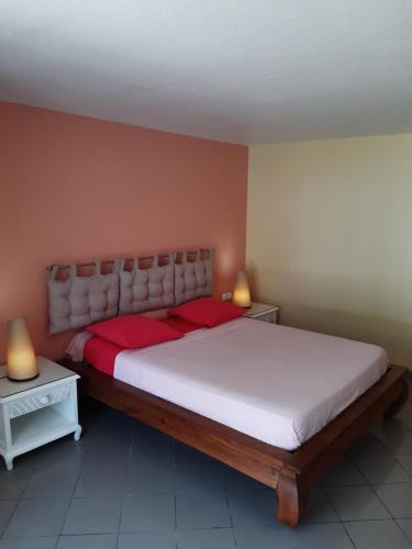 1 dormitorio con 1 cama grande y 2 mesitas de noche en Studio en bord de mer - Résidence La Vieille Tour, en Le Gosier