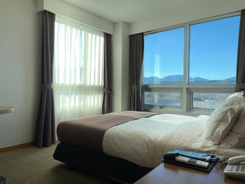 sypialnia z łóżkiem i dużym oknem w obiekcie Hotel Maremons w mieście Sokcho