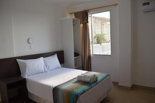 a bedroom with a bed with a towel on it at Mare S&M Casa Hostal in Manta