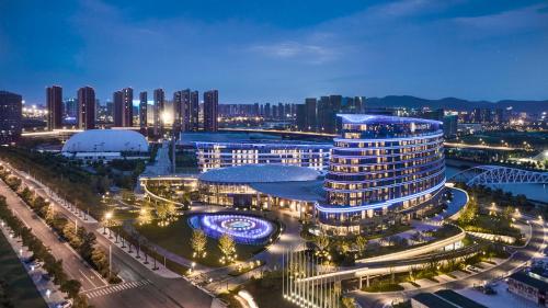 HUALUXE Nanjing Yangtze River, an IHG Hotel في نانجينغ: اطلالة ليلية على مبنى كبير في مدينة