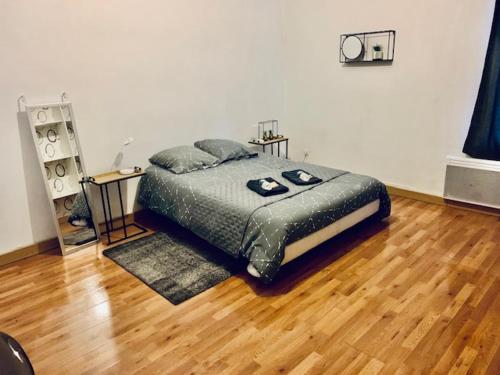 a bedroom with a bed and a wooden floor at MAISON 2 CHAMBRES - LILLE - 4 PERS - 300m METRO in Lille