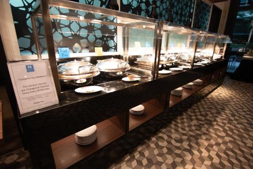 a display case in a restaurant with plates and pans at Hyatt House Kuala Lumpur, Mont Kiara in Kuala Lumpur
