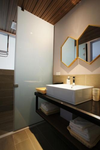 a bathroom with a large white sink and a mirror at 墾丁後灣 藍水軒海景民宿 in Checheng
