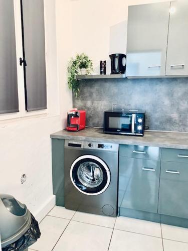 une cuisine avec un lave-linge et un micro-ondes dans l'établissement MAISON 2 CHAMBRES - LILLE - 4 PERS - 300m METRO, à Lille