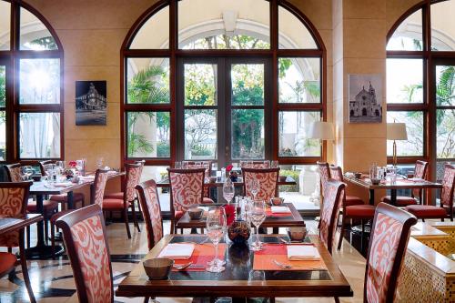 a restaurant with tables and chairs and large windows at Sofitel Macau At Ponte 16 in Macau