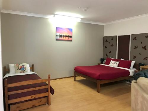a room with two beds and a bench in it at The Cosy Cottage in Port Sorell