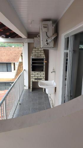 a balcony with a toilet and a sink at Residencial Costa do Encanto in Penha