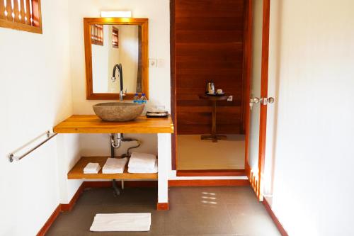 a bathroom with a sink and a mirror at La'villaris hotel & resto in Kuta Lombok