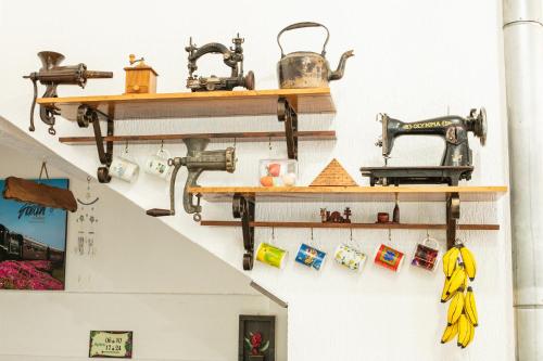 a wall with wooden shelves and sewing machines on it at Hotel Pousada Casa Tasca in Bento Gonçalves