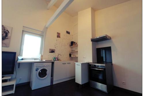 een keuken met een wasmachine en een wasmachine bij Appartement complet in Stiring-Wendel