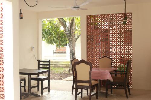 a dining room with a table and chairs and a tree at Bea rooms and studios in Cozumel