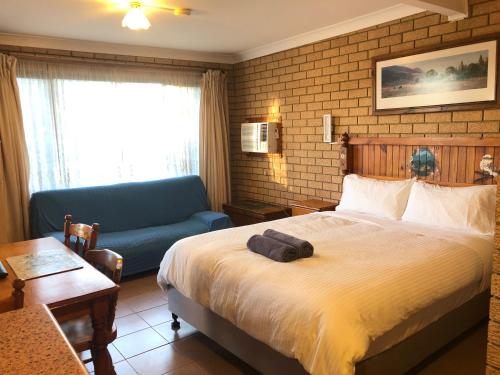 ザ・エントランスにあるLake Front Motelのベッドとソファのあるホテルの部屋