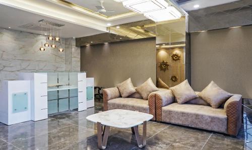 a living room with couches and a coffee table at Treebo Hotel A1 in Nagpur