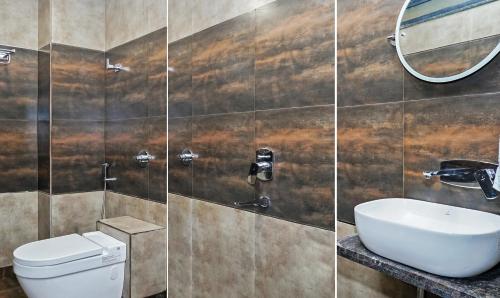 a bathroom with a toilet and a sink and a mirror at Treebo Hotel A1 in Nagpur