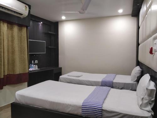 a hotel room with two beds and a tv at Hotel Bikram-A Boutique Hotel in Tezpur