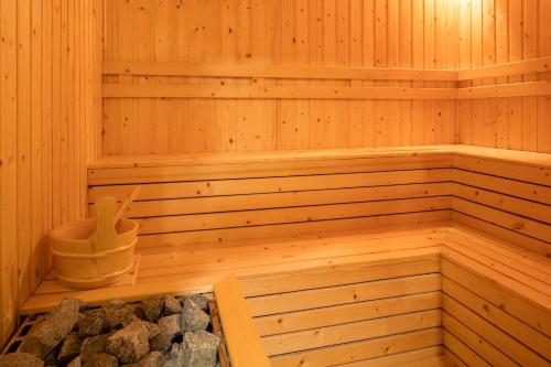 a wooden sauna with a bucket and some rocks at FLC Grand Hotel Quy Nhon in Quy Nhon