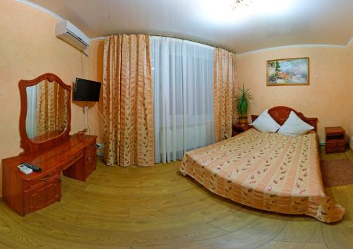 Schlafzimmer mit einem Bett, einer Kommode und einem Spiegel in der Unterkunft De Luxe in Chmilnyk