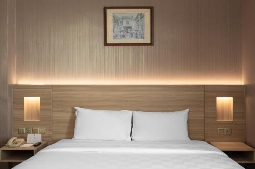 a bedroom with a bed with two lamps and a phone at Cititel Penang in George Town