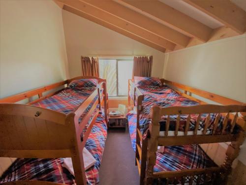 two bunk beds in a small room with a window at Mountain Retreat Suitable for 2 Families, Sleeps 8 in Mount Buller