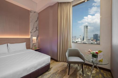 um quarto de hotel com uma cama, uma mesa e uma janela em Cititel Penang em George Town