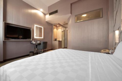 a hotel room with a large bed and a television at Cititel Penang in George Town