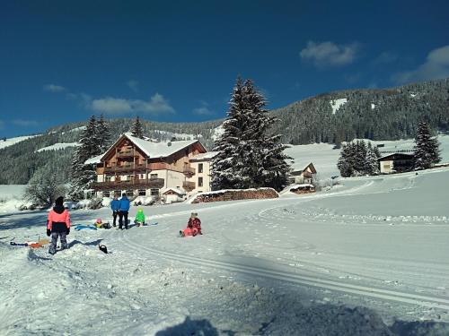 a group of people in the snow in front of a lodge at Appartments Helvetia in Villabassa