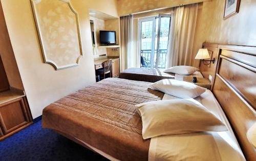 a hotel room with two beds and a window at Noufara in Piraeus