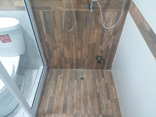 W łazience znajduje się prysznic i drewniana podłoga. w obiekcie Pingpong Place w mieście Ban Non Kum
