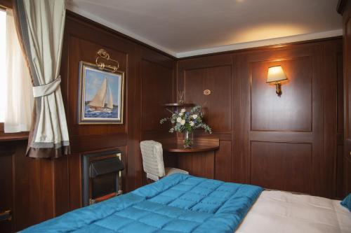 a bedroom with a blue bed and a table at Hotel Bucintoro in Venice
