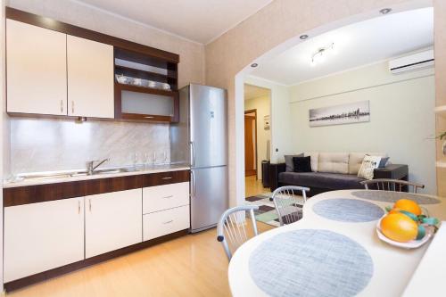 a kitchen and living room with a table and a kitchen and a couch at VIP Apartments 24/7 in Minsk