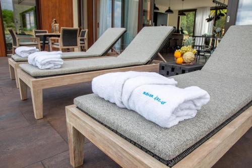 - un groupe de 4 chaises longues avec des serviettes dans l'établissement Villa Sagittaire, à Saint-Tropez