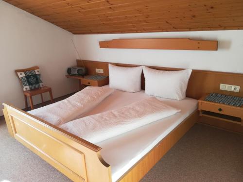 1 dormitorio con 1 cama grande con sábanas blancas en Haus Brigitte - Preise inclusive Pitztal Sommer Card, en Jerzens