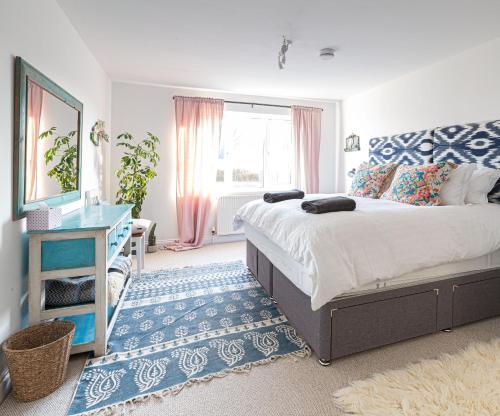 Un dormitorio con una cama grande y una alfombra azul en Harvest Moon en Newquay