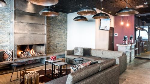 a living room filled with furniture and a fire place at Langley Hôtel Tignes 2100 in Tignes
