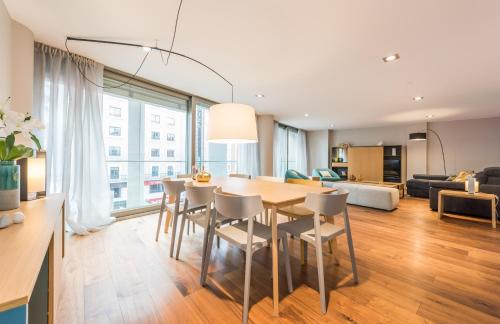 a dining room and living room with a table and chairs at Gran View Apartments in Madrid