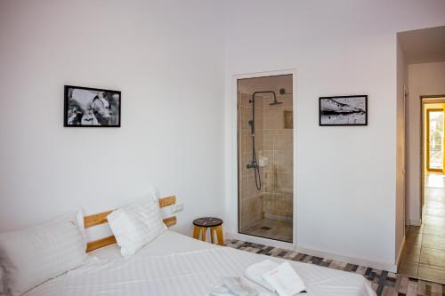 a bedroom with a white bed and a shower at Happy In Vama Veche in Vama Veche