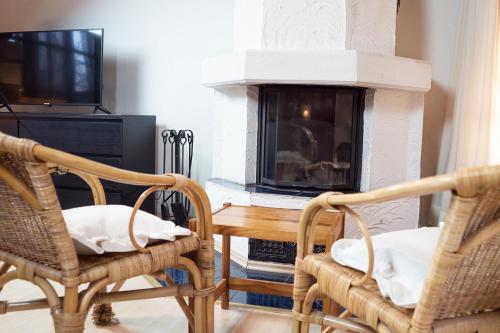 a living room with a fireplace and two chairs and a table at Reihenmittelhaus mit Kamin in Burscheid