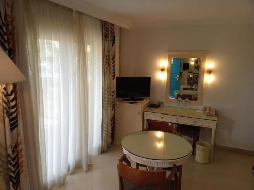 a room with a table and a desk with a television at Cairo Pyramids Hotel in Cairo