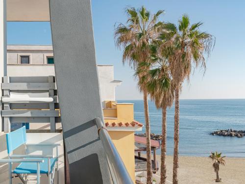 a view of the beach from a balcony with palm trees at Hotel Riviera in Anzio