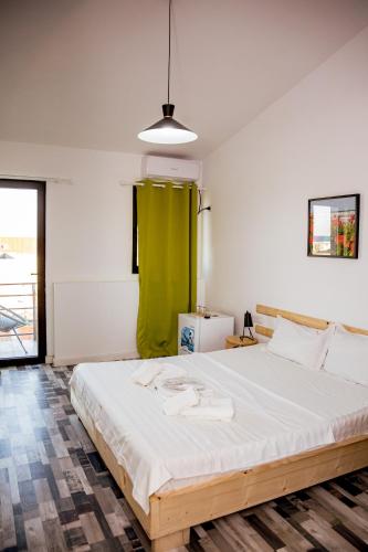 a bedroom with a large bed with a green curtain at Happy In Vama Veche in Vama Veche