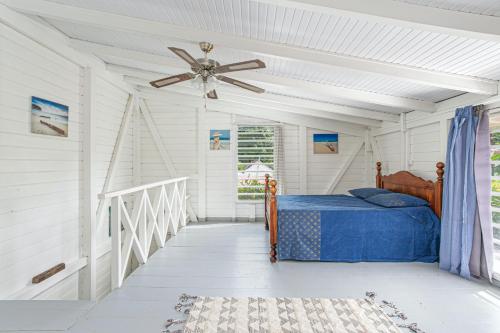 a bedroom with a bed and a ceiling fan at Appartement charmant au Carbet avec vue sur la mer - 50 m² in Le Carbet