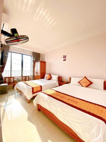 Una habitación de hotel con dos camas y una gran ventana. en Gia Hiếu Hotel, en Sơn Ðình