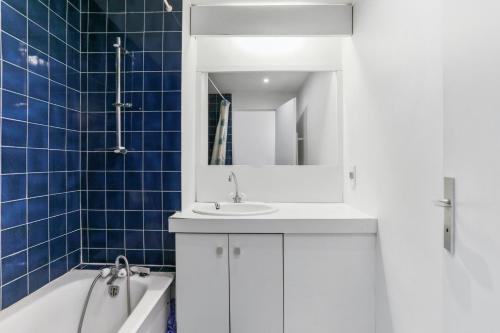 une salle de bain avec un lavabo, une baignoire et un miroir dans l'établissement Maison confortable près des plages de Saint-Raphaël, à Saint-Raphaël